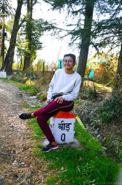 A girl sitting at a milestone of Bir