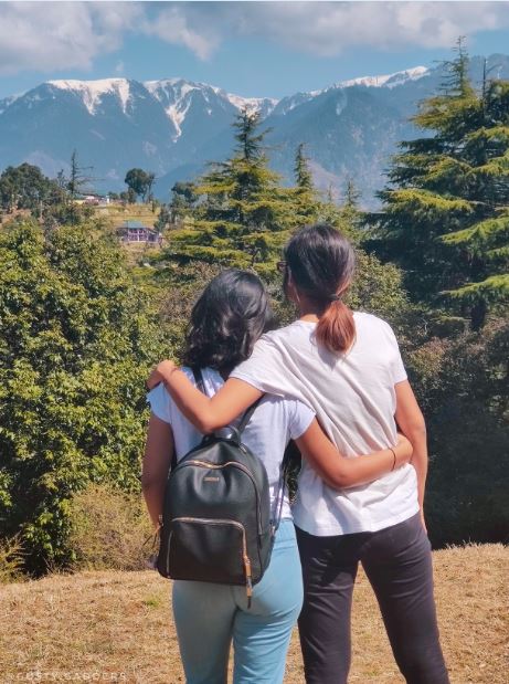 Two girls gazing the Dhauladhar Range in Himachal Pradesh